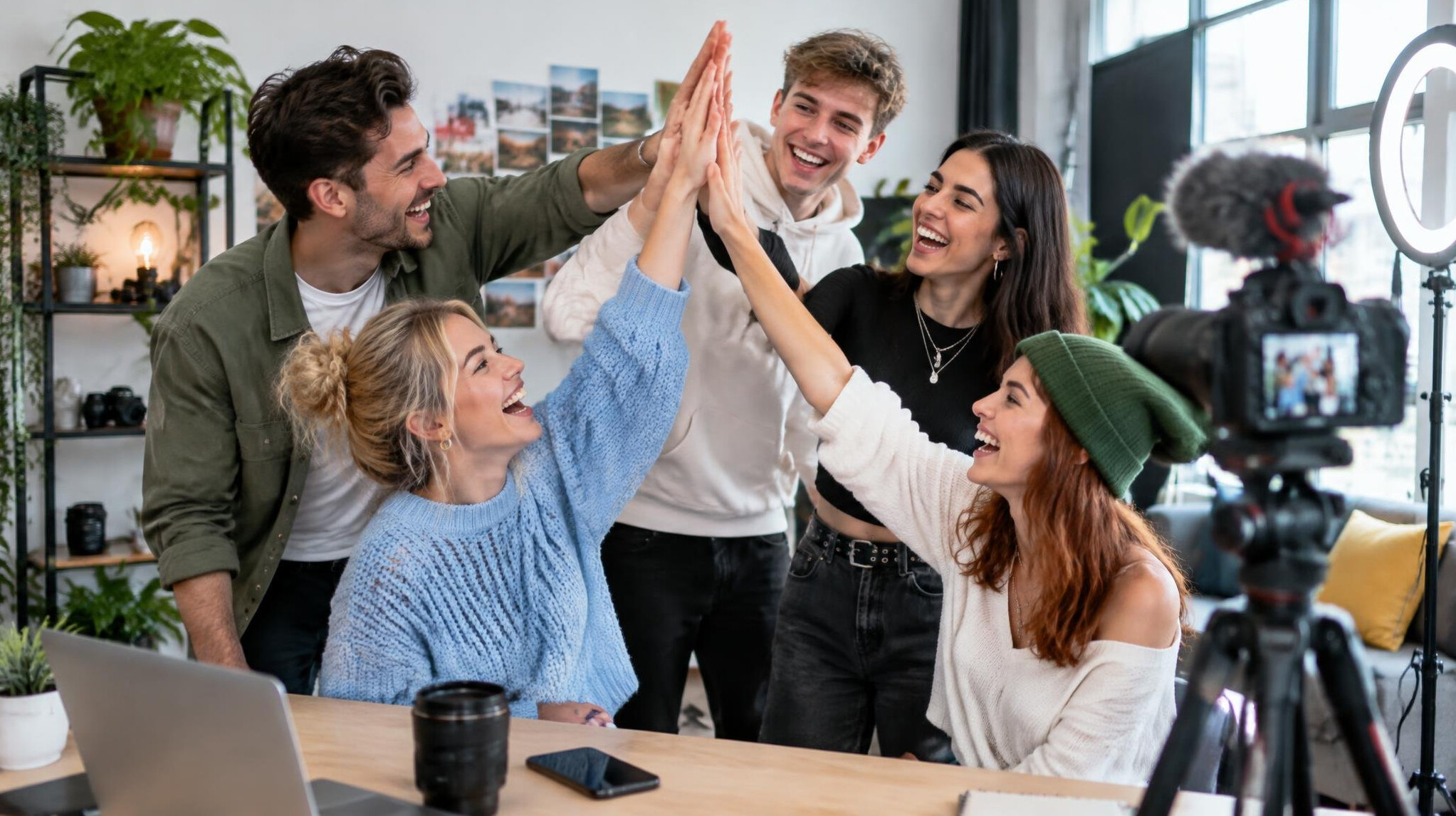 Diverse group of young creators celebrating together in a creative studio